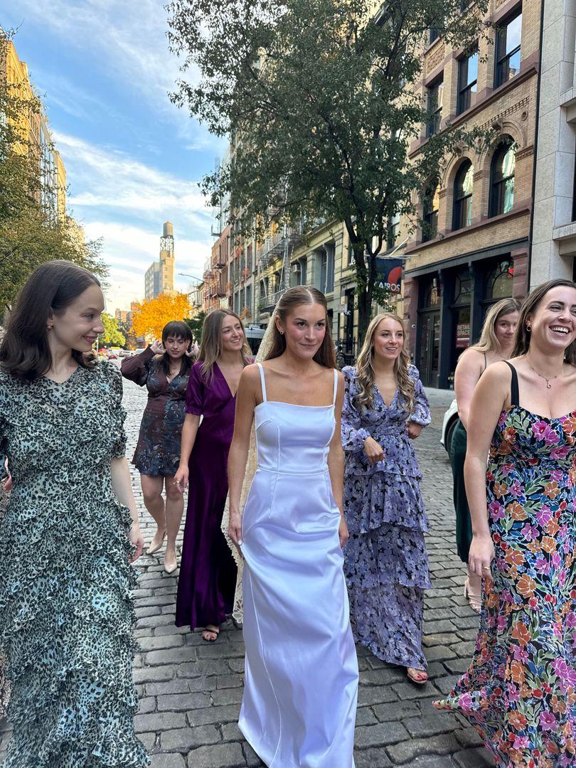 Bride and bridesmaids walking in the street.