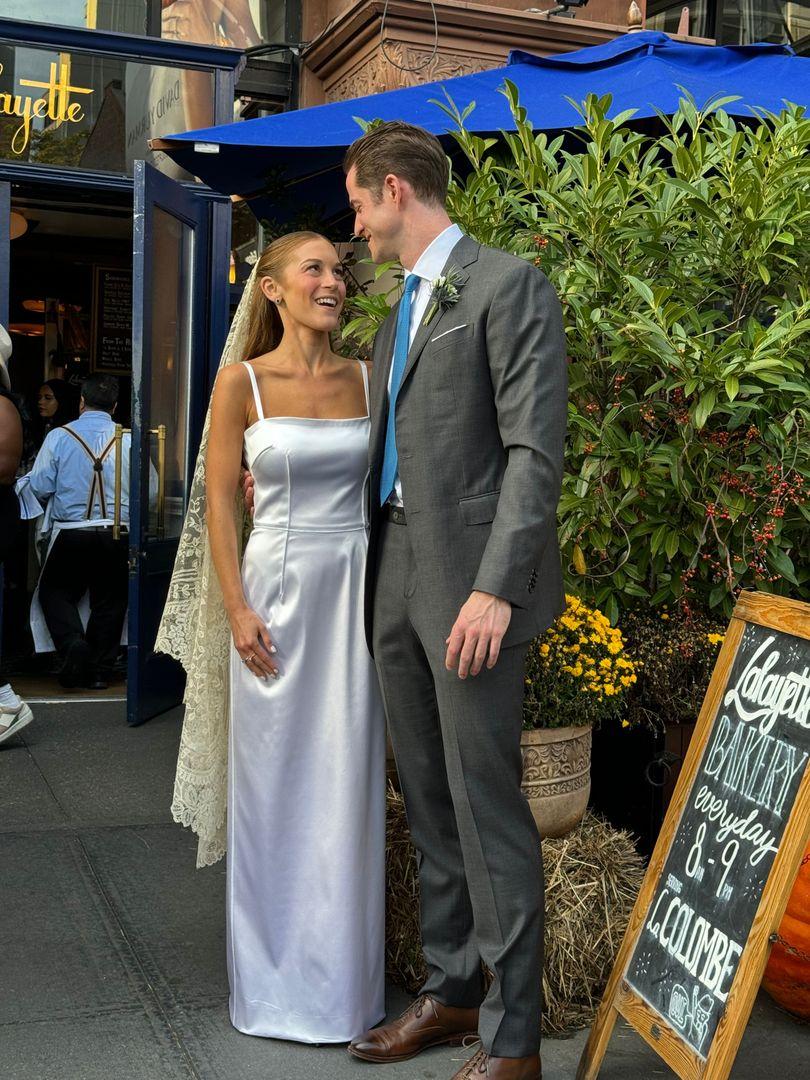 Bride and groom standing outside a hotel.