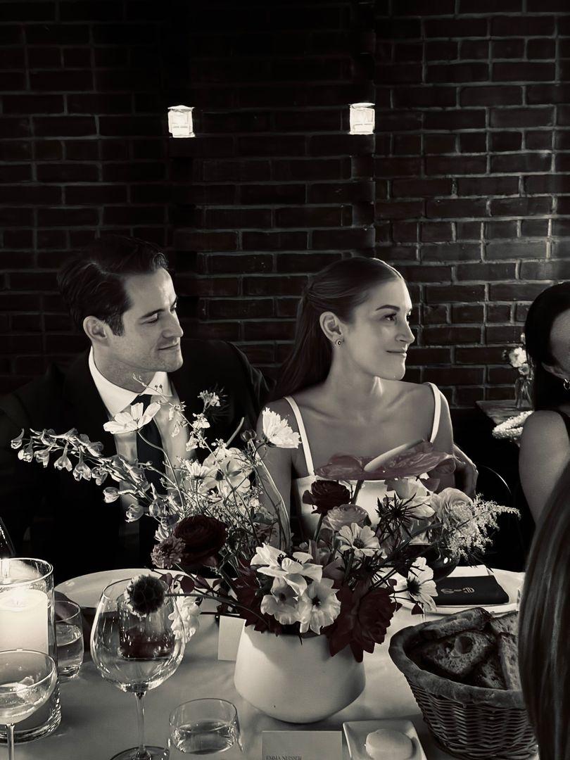 Bride and groom sitting at their table, in black and white.