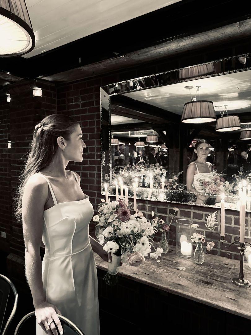 Bride looking into a mirror, in black and white.