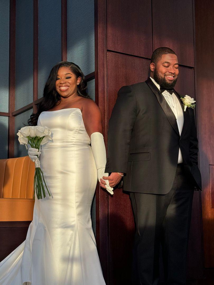 Bride and groom holding hands while smiling.