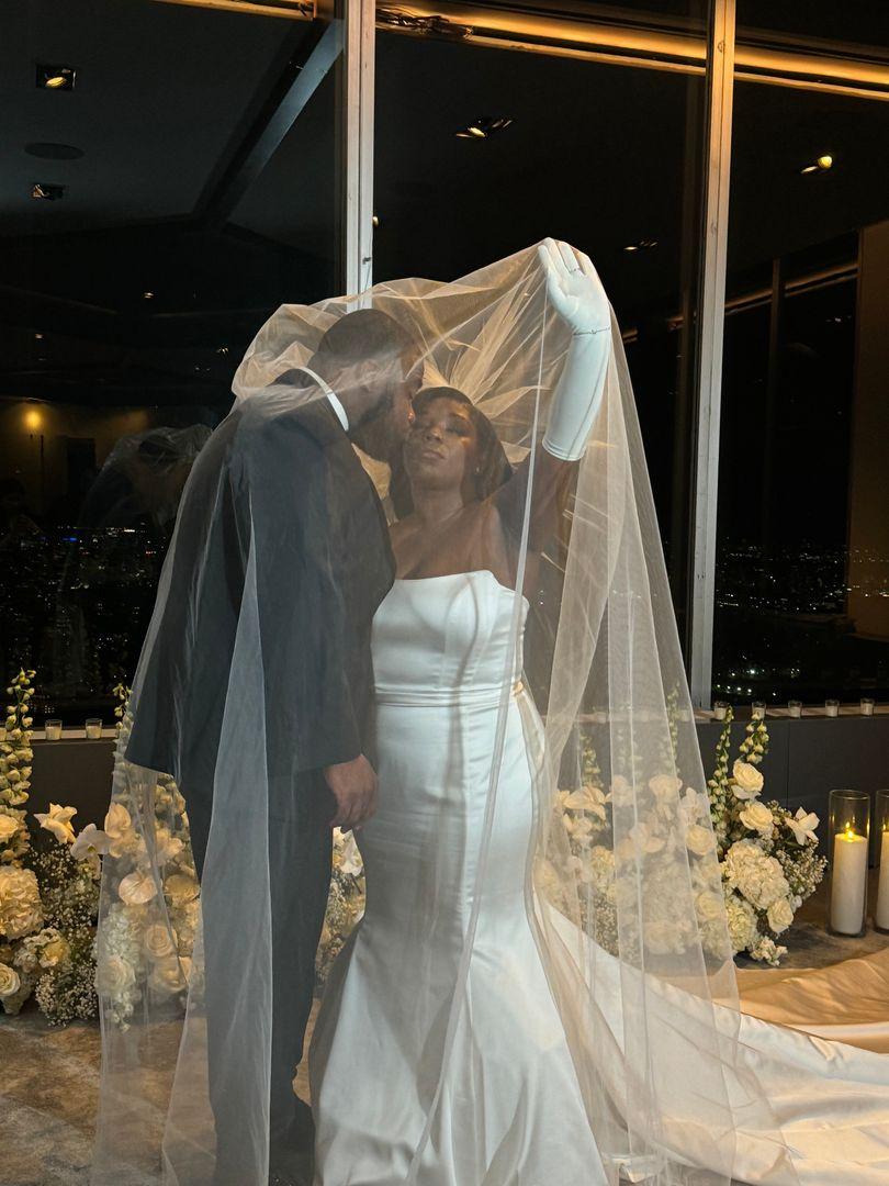 Groom kissing the bride under her veil.