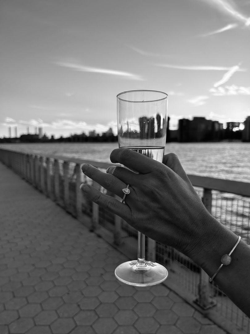 bride to be holding champage with her ring